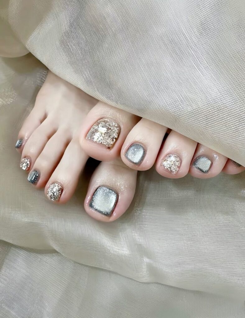 Mẫu móng chân nail đẹp với nền ánh bạc phối kim tuyến lấp lánh sang trọng, lộng lẫy cho dịp đặc biệt.