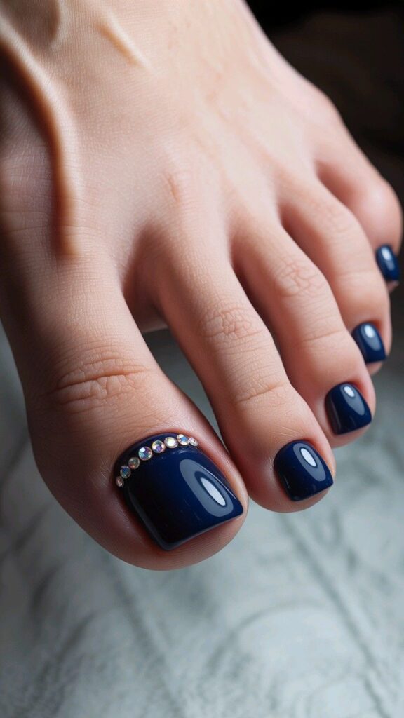 Mẫu nail chân màu xanh đính đá gems lấp lánh làm điểm nhấn, sang trọng và cuốn hút cho các dịp đặc biệt.