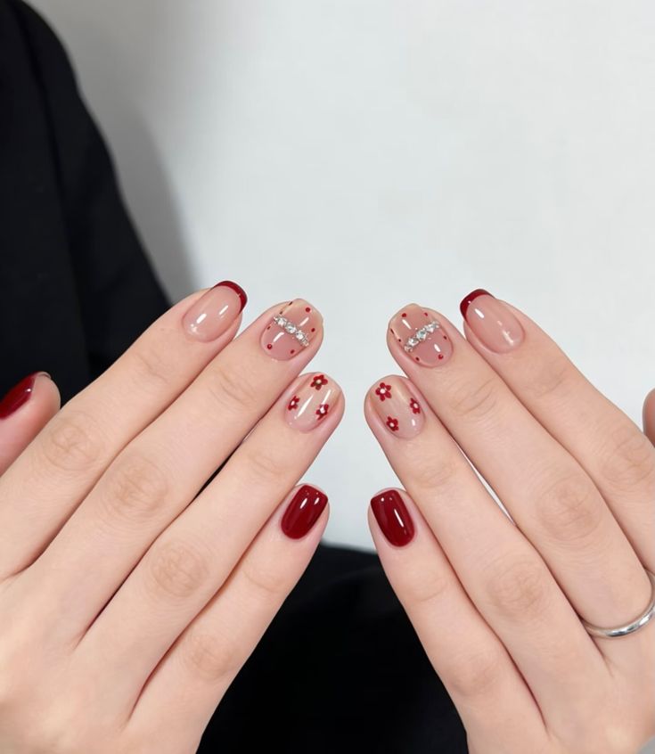 Mẫu nail đẹp cho người móng tay ngắn kiểu French viền đỏ đô, đính đá và hoa nhỏ, thanh lịch, tinh tế.