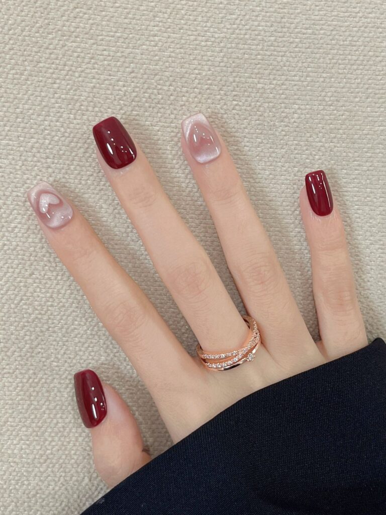 Những mẫu nail đẹp đơn giản với gam đỏ mận bóng gương phối trắng sữa hiệu ứng jelly trong, điểm nhấn trái tim nhỏ tinh tế