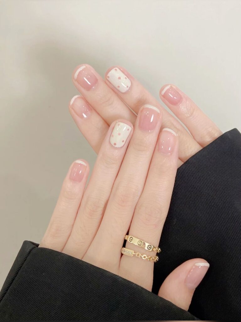 Các kiểu nail đẹp French tip viền siêu mảnh tinh tế phối họa tiết chấm bi nhỏ trên nền kem, phong cách tối giản mà vẫn nổi bật.