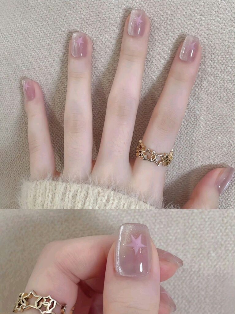 Mẫu nail mắt mèo tím hồng khói huyền ảo, mỗi móng điểm xuyết một họa tiết ngôi sao ánh nhũ nhỏ xinh, hình ảnh cận cảnh sắc nét sống động.