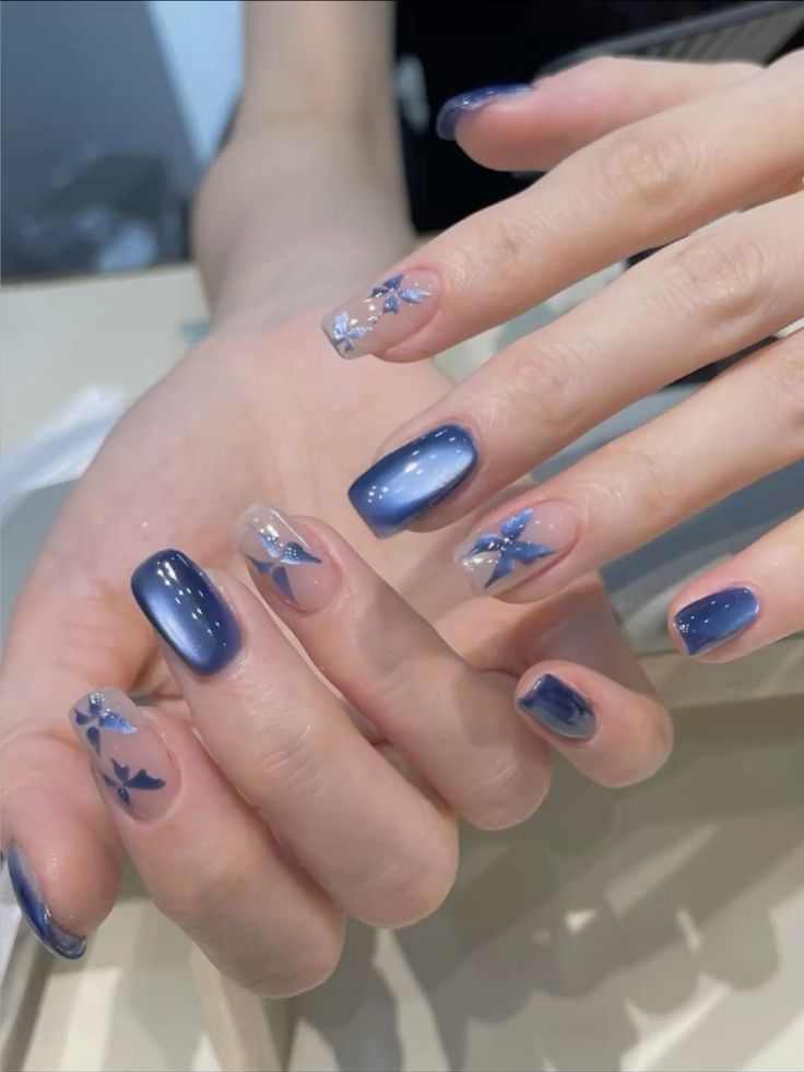 Mẫu nail màu xanh dương đẹp hiệu ứng cat-eye ánh kim phối nail trong đính họa tiết bướm xanh nhẹ nhàng, thơ mộng.