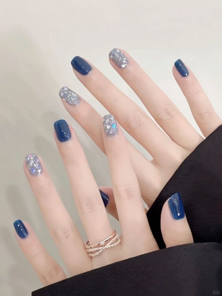 Mẫu nail màu xanh dương đẹp tông navy bóng kết hợp nail kim tuyến bạc ánh 7 màu, sang trọng và lấp lánh nổi bật.