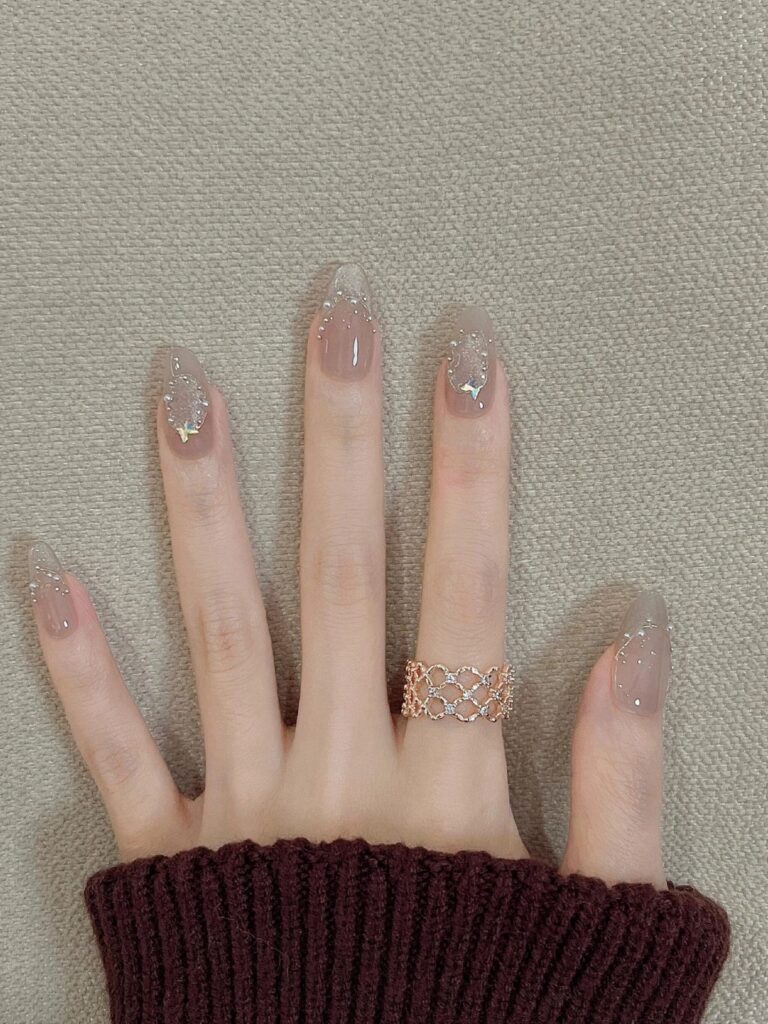 Những mẫu nail đẹp cho móng dài sang chảnh, hot nhất 2026 4 Mẫu nail móng dài đẹp dáng almond nền nude, đính đá bạc li ti và charm ánh xà cừ lấp lánh, tinh tế và sang trọng nhẹ nhàng.