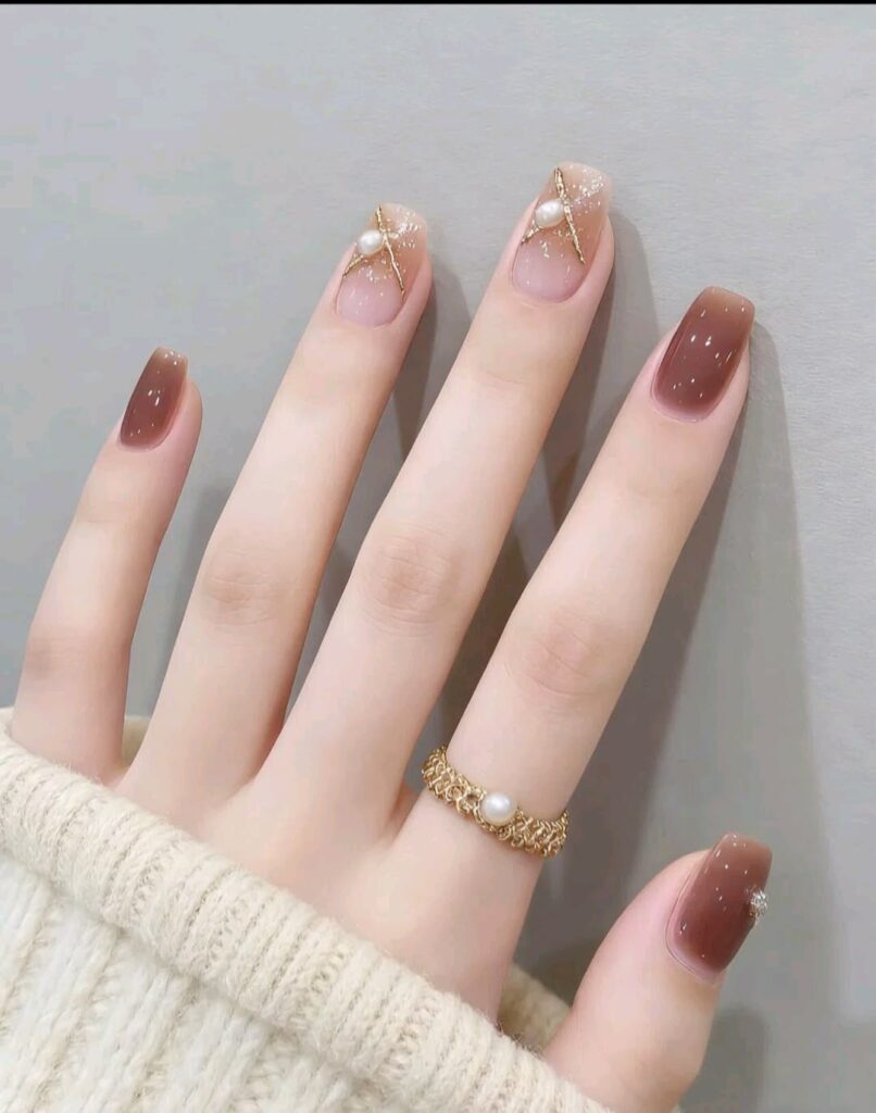 Những mẫu nail đẹp cho móng dài sang chảnh, hot nhất 2026 8 Mẫu nail móng dài đẹp ombre nâu trà, đính ngọc trai và line nhũ vàng bắt chéo, nhẹ nhàng điệu đà và rất tôn da.
