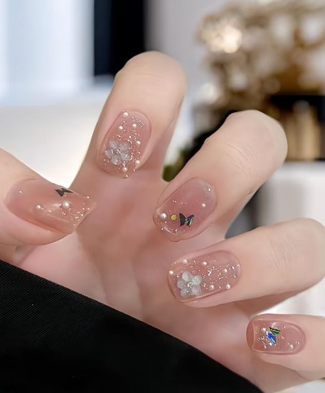Móng ngắn nude trong veo đính ngọc trai, hoa trắng và bướm – mẫu nail móng ngắn sang chảnh