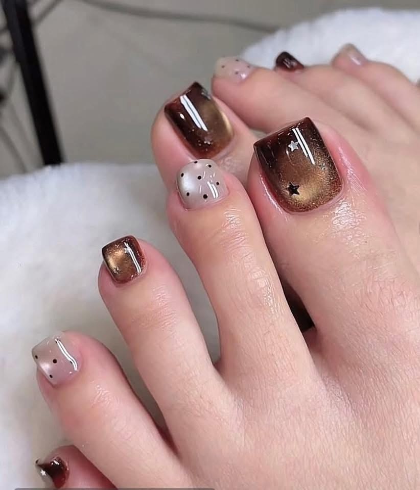 Nail bàn chân đẹp với ngón nâu hiệu ứng mắt mèo phối ngón trắng vẽ sao và chấm bi, cá tính, ấn tượng.