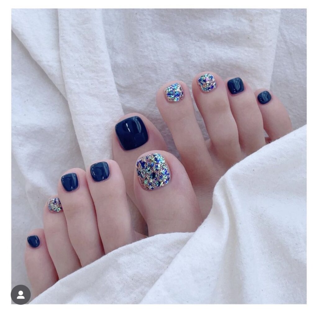 Nail chân màu xanh baby đính họa tiết lấp lánh nhiều màu nổi bật.