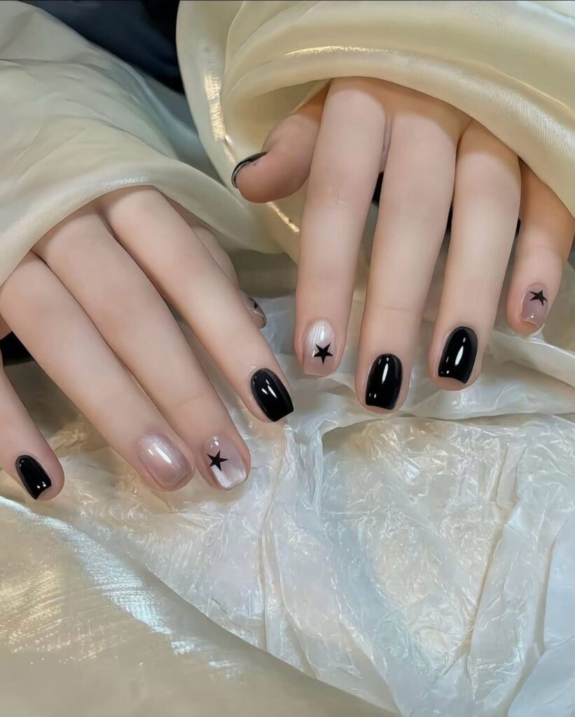 Mẫu nail đơn giản đẹp phối màu đen bóng gương và trắng ánh nhũ pearl, điểm xuyết họa tiết ngôi sao đen nhỏ xinh, cá tính nhẹ nhàng.