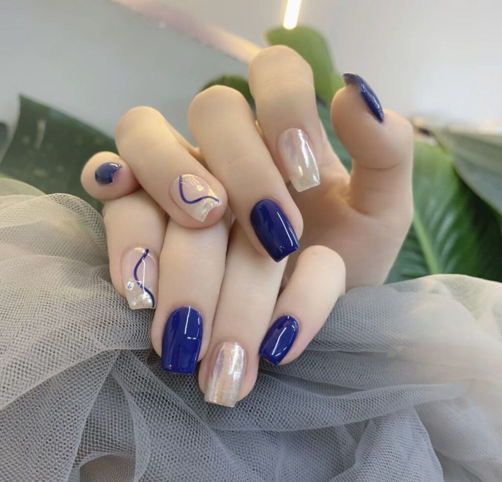 Mẫu nail màu xanh dương đẹp tông cobalt bóng phối nail nude kẻ viền xanh và ánh xà cừ, trẻ trung mà tinh tế.