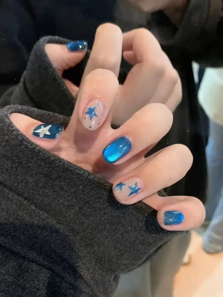 Mẫu nail màu xanh dương xanh điện cat-eye bóng phối nail nude vẽ ngôi sao xanh bạc, cá tính và trẻ trung, nổi bật.