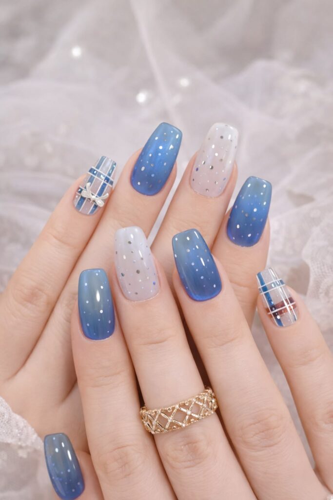 Mẫu nail màu xanh dương ombre trắng xanh rắc nhũ bạc, phối nail kẻ caro đính nơ mang chủ đề mùa đông lãng mạn.