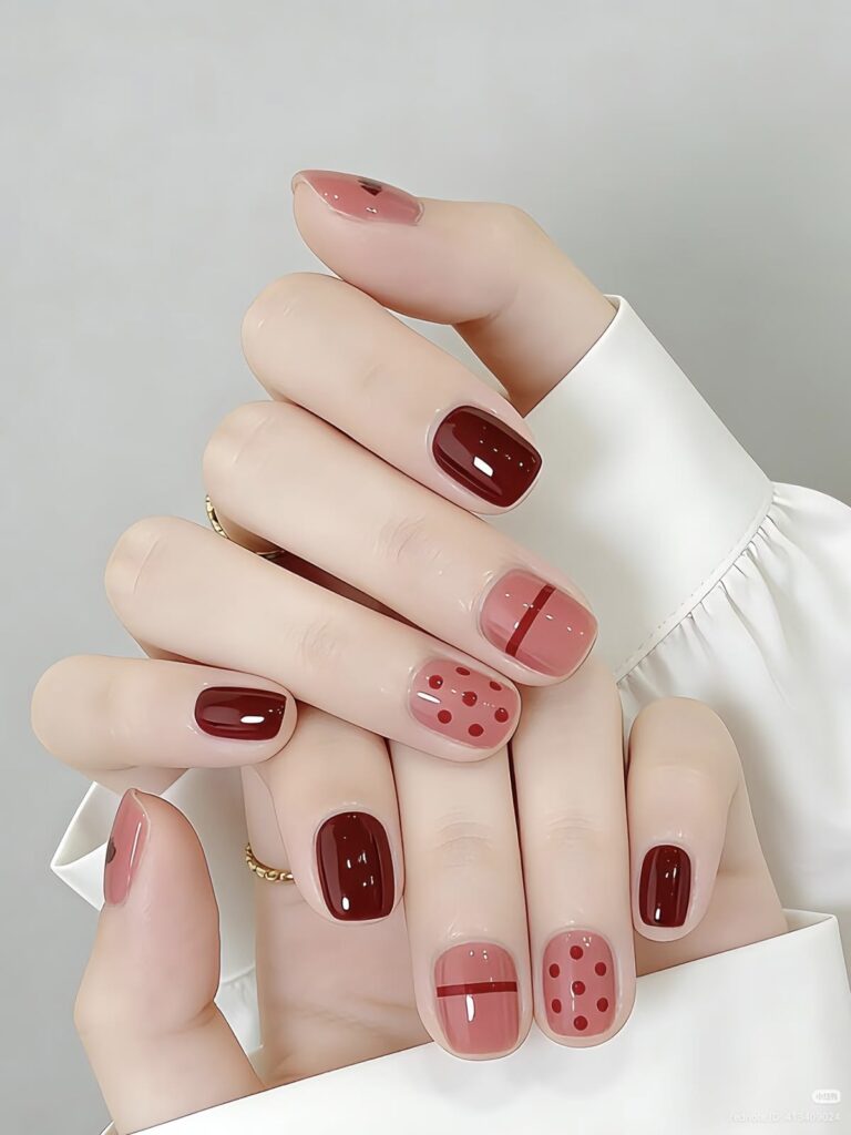 Mẫu móng nail đẹp phối đỏ đô trầm và hồng đất, điểm xuyết họa tiết chấm bi cùng line kẻ ngang theo phong cách retro cổ điển.